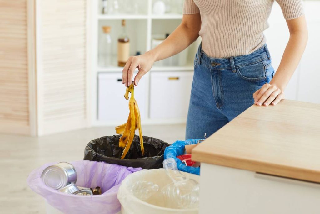 a women is dropping a banan peel into the bin