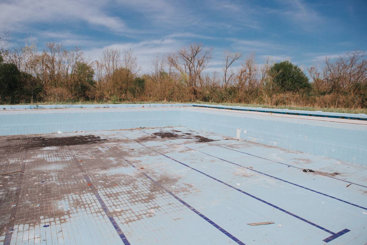 An old empty dry outdoor swimming pool in a dry park